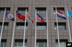 A pole, third from right, where Nauru national flag used to fly is vacant outside the Diplomatic Quarter building in Taipei, Taiwan, Monday, Jan. 15, 2024. (AP Photo/Chiang Ying-ying)