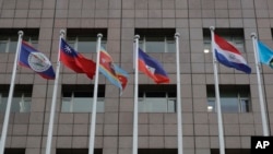 A pole, third from right, where Nauru national flag used to fly is vacant outside the Diplomatic Quarter building in Taipei, Taiwan, Monday, Jan. 15, 2024. The Pacific Island nation of Nauru says it is switching diplomatic recognition from Taiwan to China. 