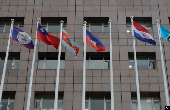 A pole, third from right, where Nauru national flag used to fly is vacant outside the Diplomatic Quarter building in Taipei, Taiwan, Monday, Jan. 15, 2024. (AP Photo/Chiang Ying-ying)