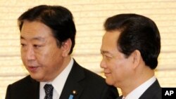 Japanese Prime Minister Yoshihiko Noda, left, escorts his Vietnamese counterpart Nguyen Tan Dung for their dinner at Noda's official residence in Tokyo on October 31, 2011.