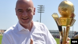 Le président de la FIFA, Gianni Infantino, tient un trophée dedies aux "travailleurs de la Coupe du au Qatar 2016" à Doha, Qatar, 22 avril 2016. epa/ STRINGER