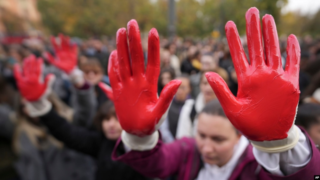 Protesters shout slogans with red paint on thire hands symbolizing blood, demanding arrests, two days after a concrete canopy collapsed at a railway station in Novi Sad, killing 14 people and injuring three, during a protest in Belgrade, Nov. 3, 2024. 
