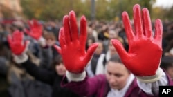 Protesters shout slogans with red paint on thire hands symbolizing blood, demanding arrests, two days after a concrete canopy collapsed at a railway station in Novi Sad, killing 14 people and injuring three, during a protest in Belgrade, Nov. 3, 2024. 