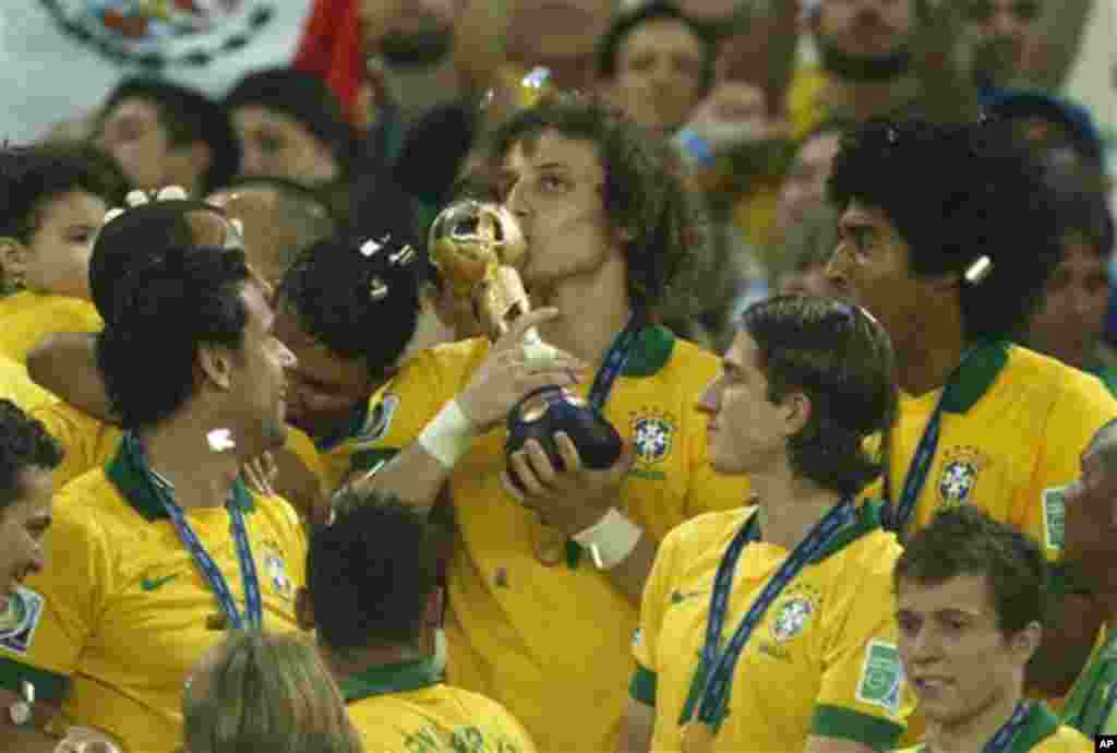 Brazil's David Luiz kisses the trophy after winning the soccer Confederations Cup final between Brazil and Spain at the Maracana stadium in Rio de Janeiro, Brazil, Sunday, June 30, 2013. (AP Photo/Bruno Magalhaes) 