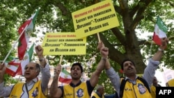 Activists of an Iranian exile opposition group hold placards reading 'Deliver the Iranian diplomat-terrorist to Belgium' during a demonstration calling for the extradition of Assadollah Assadi, in front of the Federal Foreign Office in Berlin, Germany, July 11, 2017.