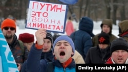 RUSSIA – Truck driver holding a sign "Putin is war and poverty" during a protest in St.Petersburg, Feb. 6, 2016