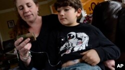 Heidi Elbarky memberikan insulin kepada anak laki-lakinya, Omar, 8 Tahun, di kediamannya di Spring Hill, Tennessee, 12 Maret 2014.