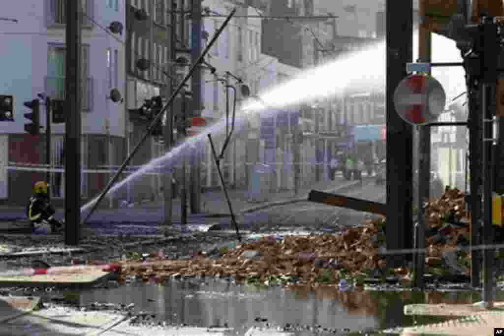A firefighter sprays water onto the furniture store set on fire by rioters last night in Croydon, south London, Tuesday, Aug. 9, 2011. A wave of violence and looting raged across London and spread to three other major British cities Tuesday, as authoritie