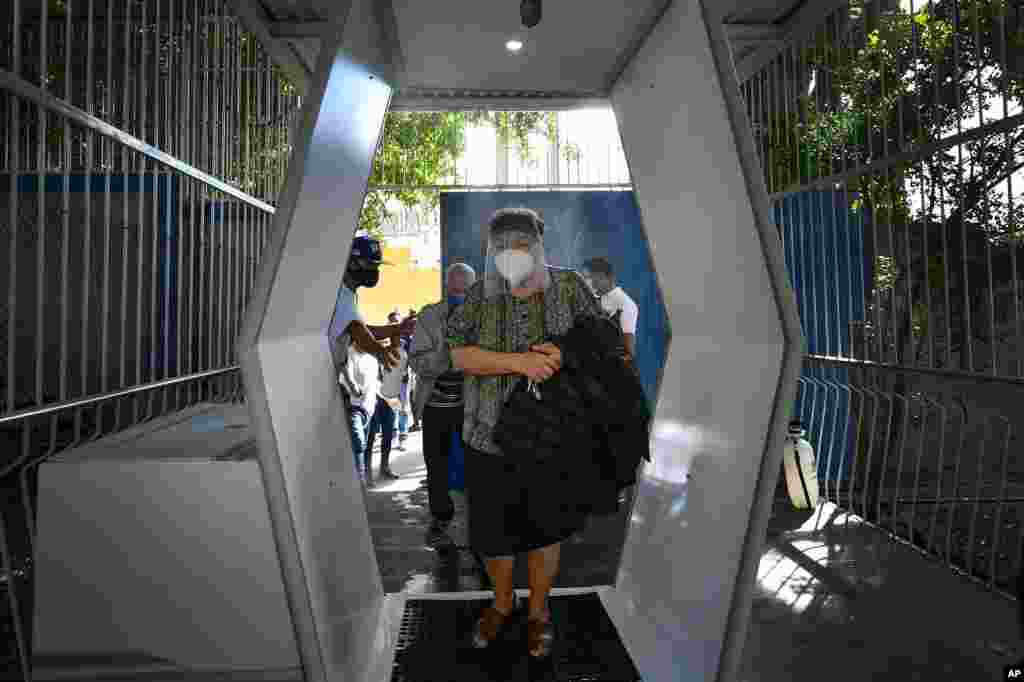 Una mujer con m&#225;scara protectora para protegerse de la propagaci&#243;n del nuevo coronavirus llega a votar en un colegio electoral para ecuatorianos que viven en Caracas, Venezuela, el domingo 7 de febrero de 2021.