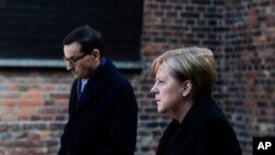 German Chancellor Angela Merkel and Polish Prime Minister Mateusz Morawiecki attend a wreath laying ceremony at the death wall in the former Nazi death camp of Auschwitz-Birkenau in Oswiecim, Germany, Dec. 6, 2019.