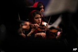 FILE - An Iranian musician plays the violin while performing pieces by 19th-century Russian composers in Tehran Symphony Orchestra at Unity Hall, in Tehran, Iran, July 3, 2019.