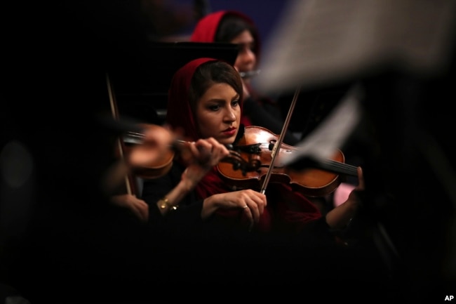 FILE - An Iranian musician plays the violin while performing pieces by 19th-century Russian composers in Tehran Symphony Orchestra at Unity Hall, in Tehran, Iran, July 3, 2019.