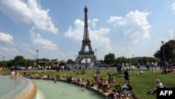 People cool themselves at the Fontaine du Trocadero in front of The Eiffel Tower in Paris 