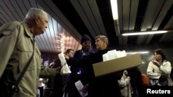 A leader of ANO 2011 movement Andrej Babis (C) hands out donuts during an election campaign rally at a subway station in Prague, Oct. 23, 2013. 