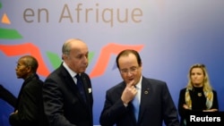 FILE - French President Francois Hollande (R) and Foreign Minister Laurent Fabius attend the opening session of the Elysee Summit for Peace and Security in Africa at the Elysee Palace, in Paris, Dec. 6, 2013.