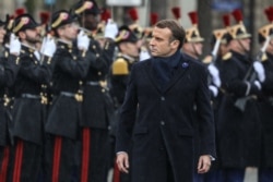 French President Emmanuel Macron reviews troops during a ceremony at the Arc de Triomphe in Paris on Nov. 11, 2019.