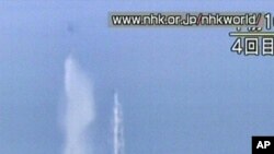 This screengrab taken off Japanese national broadcaster NHK shows a Japanese military twin-rotor cargo helicopter dumping water onto reactor no. 3 at the stricken Fukushima nuclear power plant on March 17, 2011.