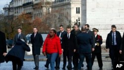 El presidente de Francia, Emmanuel Macron (centro), deja el Arco del Triunfo el día después de violentas manifestaciones que dejaron daños en el amado monumento de París. Diciembre 2 de 2018.