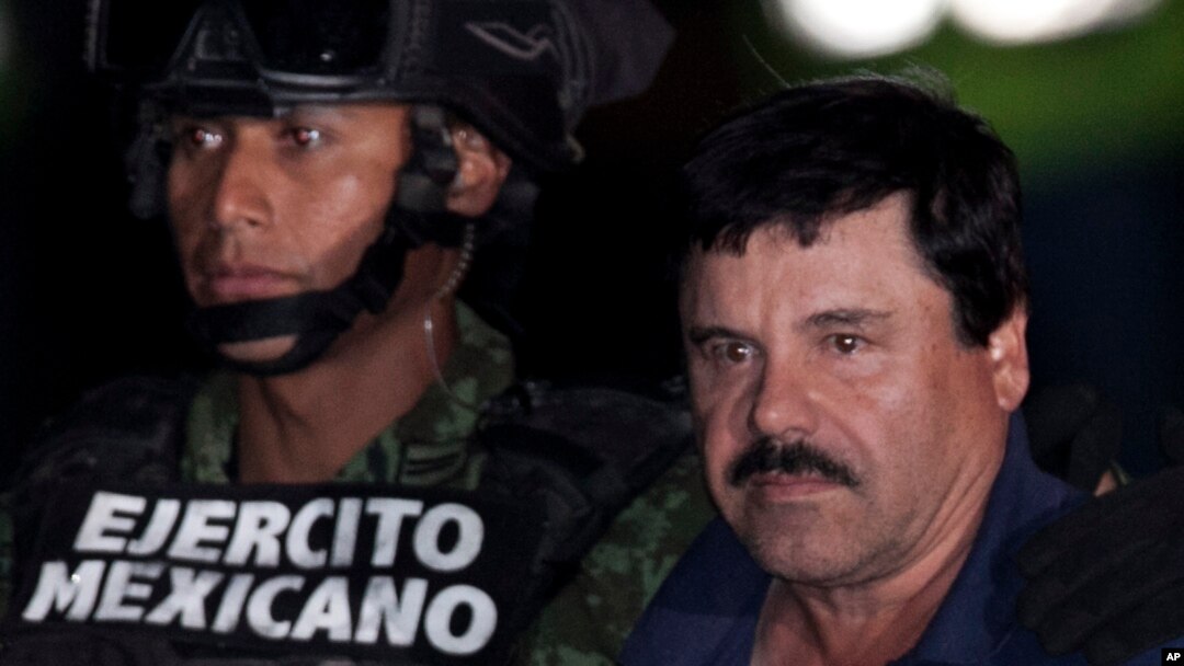 FILE - Mexican drug lord Joaquin "El Chapo" Guzman, right, is escorted by soldiers and marines to a waiting helicopter, at a federal hangar in Mexico City, Jan. 8, 2016. 