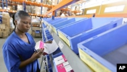 A worker looks at the stock of medicine in the Pharmacie de la Sante Publique (Public Health Medicine) warehouse in Abidjan, March 17, 2011