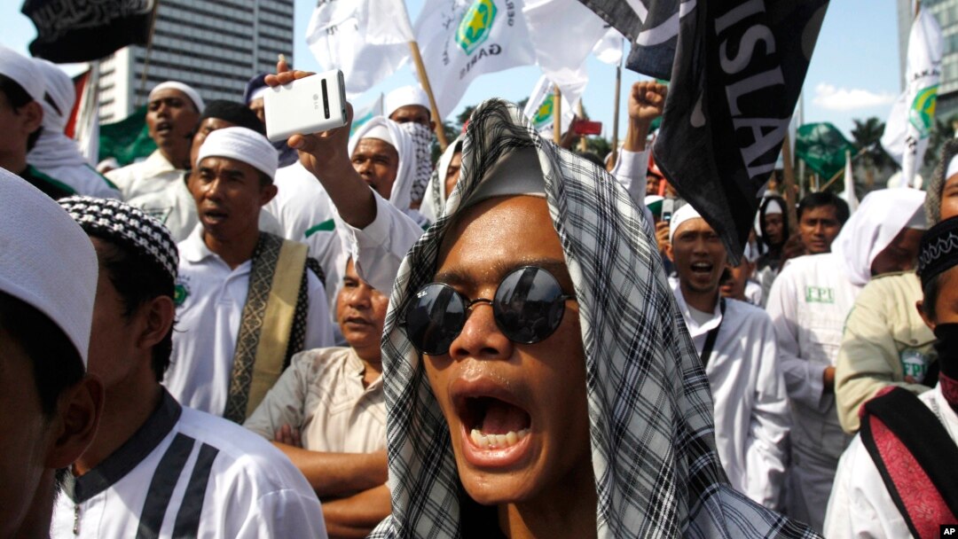 FILE - Members of the militant Islamic Defenders Front (FPI) shout slogan during a demontration in Jakarta, Indonesia.