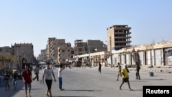 People walk along a street in Deir el Zour, Syria, in this photo provided by SANA, Sept. 11, 2017.