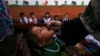 FILE - A health worker administers a polio vaccine to a child at a school in Peshawar, Pakistan, Sept. 9, 2024. 