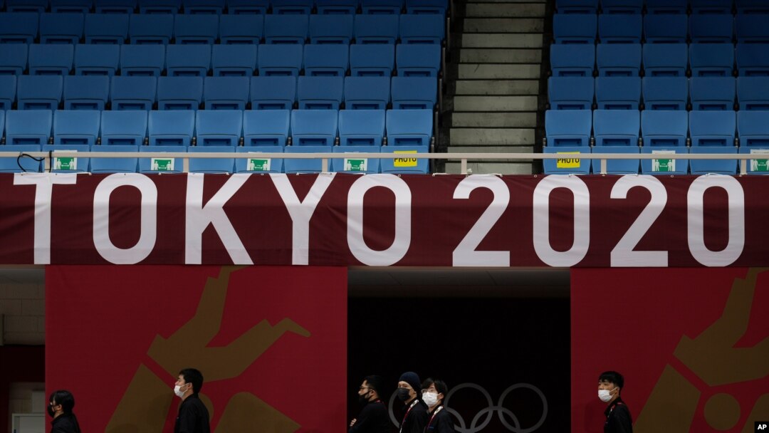 Staf berjalan di bawah logo Tokyo 2020 di lapangan permainan judo di Nippon Budokan menjelang Olimpiade Musim Panas 2020, Jumat, 23 Juli 2021, di Tokyo, Jepang. (Foto: AP/Vincent Thian)
