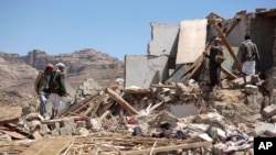 FILE - People inspect the rubble of a house destroyed by a Saudi-led airstrike in the outskirts of Sana'a, Yemen, Feb. 16, 2017.