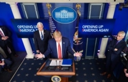 U.S. President Donald Trump, flanked by U.S. Vice President Mike Pence and Director of the National Institute of Allergy and Infectious Diseases Anthony Fauci, right, speaks in the Brady Briefing Room of the White House, April 16, 2020.