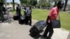 South Sudanese men carry luggage as they walk towards Tel Aviv's central bus station to board a bus to Ben Gurion airport, Israel, June 17, 2012. 