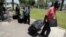 South Sudanese men carry luggage as they walk towards Tel Aviv's central bus station to board a bus to Ben Gurion airport, Israel, June 17, 2012. 