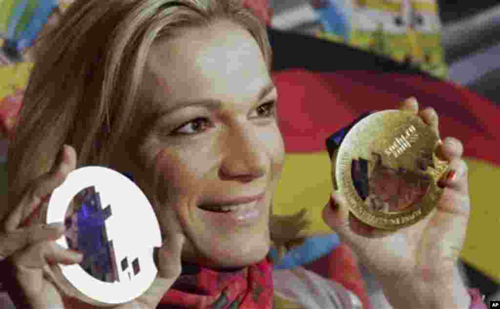 Germany's Maria Hoefl-Riesch poses with her gold and silver medals at the German house at the 2014 Winter Olympics, Saturday, Feb. 15, 2014, in Krasnaya Polyana, Russia. Hoefl-Riesch finished second in the women's super-G after taking the gold medal in th
