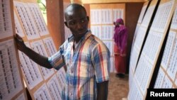 A man searches for his name on a list of eligible voters at an election center in Bamako, July 23, 2013.