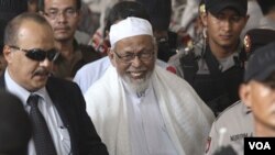 Ulama radikal Abu Bakar Ba'asyir meninggalkan pengadilan Jakarta Selatan setelah divonis 15 tahun penjara (16/6).