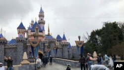 En esta foto de archivo del 13 de marzo de 2020, visitantes toman fotos en Disneyland. Anaheim, California.