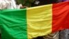 People seeking refuge from Tuareg separatist rebel group MNLA display a Malian flag in a military camp in the northern town of Kidal, July 17, 2013. 
