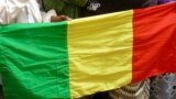 People seeking refuge from Tuareg separatist rebel group MNLA display a Malian flag in a military camp in the northern town of Kidal, July 17, 2013. 