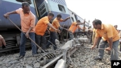 Railway workers remove a damaged slab from the track after a passenger train derailed in Bangapara village near the northeastern city of Guwahati, India, February 3, 2012.