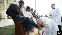 Le pape François embrasse le pied d'un homme pendant le rituel du lavement des pieds au centre de réfugiés Castelnuovo di Porto, à 30km (18, 6 miles) de Rome, 24 mars 2016. 