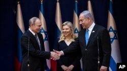 Perdana Menteri Israel Benjamin Netanyahu dan istrinya Sarah menyambut Presiden Rusia Vladimir Putin (kiri) di kediaman resmi di Yerusalem, 23 Januari 2020. Putin menghadiri peringatan 75 tahun pembebasan kamp Nazi Auschwitz oleh tentara Rusia.