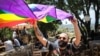 A man unfurls the rainbow flag at a small event held by Beirut Pride, May 21, 2017. (J. Owens/VOA)