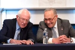 FILE - Senate Majority Leader Chuck Schumer of N.Y., right, sits next to Sen. Bernie Sanders, I-Vt., during a meeting with Senate Democrats on the Budget Committee, on Capitol Hill in Washington, June 16, 2021.