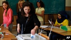 A woman casts her vote at a polling station during municipal elections in Beirut, Lebanon, May 8, 2016. Sunday's vote is the first since an eight-month trash crisis in Beirut sparked massive anti-government protests.