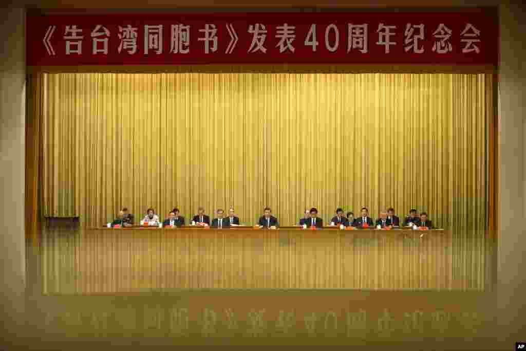 A banner is reflected in a polished surface as Chinese President Xi Jinping, center, speaks during an event to commemorate the 40th anniversary of the Message to Compatriots in Taiwan at the Great Hall of the People in Beijing.