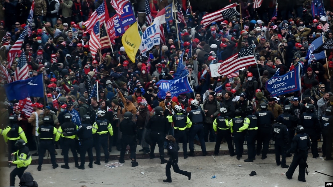 Полиция и сторонники президента Трампа у здания Капитолия. 6 января 2021. 