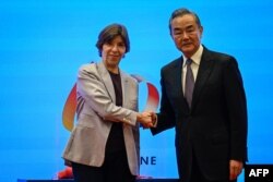 Menteri Luar Negeri China Wang Yi (kanan) dan Menteri Luar Negeri Prancis Catherine Colonna berjabat tangan di Beijing pada 24 November 2023. (Foto: Jade GAO/AFP)