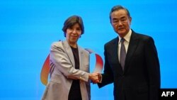 Chinese Foreign minister Wang Yi (R) and French Foreign minister Catherine Colonna shake hands during the 6th China-France high-level dialogue on people-to-people exchange at Peking University in Beijing on November 24, 2023.