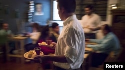 A waiter carries dishes for diners at the "Ciboulette Prive" in Caracas, Venezuela, June 9, 2015. 