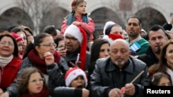 People attend Christmas celebrations outside the Church of the Nativity in the West Bank city of Bethlehem, Dec. 24, 2017. 